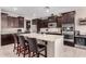 Kitchen island features granite countertops, barstool seating, and stainless steel appliances at 3687 E Blue Spruce Ln, Gilbert, AZ 85298