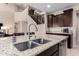 Kitchen with granite counters, stainless appliances, dark wood cabinets and a view of the staircase at 3687 E Blue Spruce Ln, Gilbert, AZ 85298