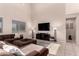 Comfortable living room with high ceilings, tile floors, a large sectional, and plenty of natural light at 3687 E Blue Spruce Ln, Gilbert, AZ 85298