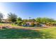 Picturesque park area featuring a meandering trail, lush greenery, and serene pond with playground at 3687 E Blue Spruce Ln, Gilbert, AZ 85298