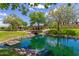 A tranquil pond with lush landscaping, stone bridge and green space creates a serene community setting at 3687 E Blue Spruce Ln, Gilbert, AZ 85298