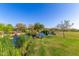 Scenic pond view with lush green grass and mature landscaping in a community park setting at 3687 E Blue Spruce Ln, Gilbert, AZ 85298