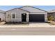 Charming single-story home featuring a gray facade, black door, and a two-car garage at 3806 N Camden Dr, Florence, AZ 85132