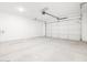 Spacious garage with concrete flooring, an automatic garage door, and white walls at 3806 N Camden Dr, Florence, AZ 85132