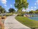 Smooth concrete walking path alongside a tranquil lake surrounded by lush landscaping at 3806 N Camden Dr, Florence, AZ 85132