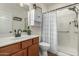 Clean bathroom with a modern vanity, white countertop, and a shower with a stylish patterned curtain at 3935 E Blue Spruce Ln, Gilbert, AZ 85298