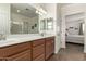 Bathroom features a dual sink vanity, large mirror and separate door to bedroom at 3935 E Blue Spruce Ln, Gilbert, AZ 85298