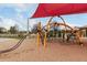 Community playground featuring a unique orange climbing structure on a soft sand surface at 3935 E Blue Spruce Ln, Gilbert, AZ 85298