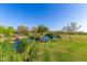 Scenic pond with lush green grass, mature trees, and a covered picnic area, offering a tranquil community space at 3935 E Blue Spruce Ln, Gilbert, AZ 85298