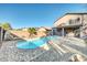 Kidney-shaped pool surrounded by desert landscape and brick accents at 42015 W Hillman Dr, Maricopa, AZ 85138