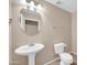 Elegant bathroom with a pedestal sink, toilet, and oval mirror at 42015 W Hillman Dr, Maricopa, AZ 85138