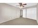 This bedroom features neutral walls, carpet, and a ceiling fan with a light at 42015 W Hillman Dr, Maricopa, AZ 85138