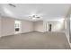 Spacious bedroom with carpet flooring, a ceiling fan, and doorways to a bathroom and closet at 42015 W Hillman Dr, Maricopa, AZ 85138