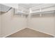 Walk-in closet with carpet flooring and white shelving on two sides at 42015 W Hillman Dr, Maricopa, AZ 85138