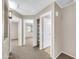 Hallway view leading to two bedrooms, one with an ensuite bathroom with carpeted floors at 42015 W Hillman Dr, Maricopa, AZ 85138