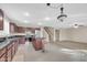 Spacious kitchen featuring granite counters, stainless steel appliances, with an open view to the carpeted living room at 42015 W Hillman Dr, Maricopa, AZ 85138
