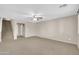 Spacious living room with neutral carpet, fan, and a staircase to the second level at 42015 W Hillman Dr, Maricopa, AZ 85138