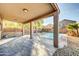 Inviting covered patio with stamped concrete overlooks a refreshing pool and desert landscaping at 42015 W Hillman Dr, Maricopa, AZ 85138