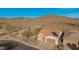 Aerial view of desert home with a red tiled roof, three-car garage, and solar panels amid the desert landscape at 42943 N Livingstone Way, Anthem, AZ 85086