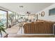 Open-concept living room with a large sectional, wood floors, and a bright sunroom with dining area at 4308 E Montecito Ave, Phoenix, AZ 85018