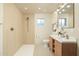 Modern bathroom with a walk-in shower and double sink vanity with wood-colored cabinetry at 4731 E Monte Vista Rd, Phoenix, AZ 85008