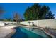 Backyard pool is surrounded by landscaping and a tall fence for privacy at 4731 E Monte Vista Rd, Phoenix, AZ 85008