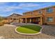 Spacious backyard with artificial grass, fire pit, and a covered patio area at 5032 W Yearling Rd, Phoenix, AZ 85083