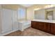 Bathroom featuring a large glass block window, a shower, soaking tub, and wood cabinets with double sinks at 5032 W Yearling Rd, Phoenix, AZ 85083
