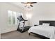 Bedroom featuring bright natural light from shuttered windows with exercise equipment and comfortable bed at 5032 W Yearling Rd, Phoenix, AZ 85083