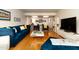 This living room contains an open floor plan with hardwood floors and features a blue velvet sofa and black accent chairs at 5124 N 31St Pl # 536, Phoenix, AZ 85016