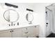 Bright bathroom featuring a dual vanity with quartz countertop, round mirrors, and modern black fixtures at 5532 E Crocus Dr, Scottsdale, AZ 85254