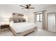 Bright bedroom featuring a ceiling fan, a wood-framed bed with throw pillows, and natural light from the window at 5532 E Crocus Dr, Scottsdale, AZ 85254