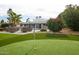 Backyard putting green with view of white home, entertaining area, and swimming pool in distance at 5532 E Crocus Dr, Scottsdale, AZ 85254