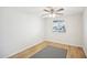 A simple bedroom with a ceiling fan, wood-look flooring and a window, creating a bright and comfortable atmosphere at 6123 W Karen Lee Ln, Glendale, AZ 85306