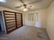 Cozy bedroom with neutral walls, carpet, a ceiling fan, and a large bookshelf at 6132 E Decatur St, Mesa, AZ 85205