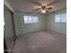 Bright bedroom with neutral walls, carpet, a ceiling fan, and a mirrored closet at 6132 E Decatur St, Mesa, AZ 85205