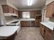 Traditional kitchen with wooden cabinets, white countertops, stainless steel dishwasher and a tiled floor at 6132 E Decatur St, Mesa, AZ 85205
