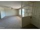Open living room featuring neutral carpet, a bright window, and a partial divider wall with built-in shelving at 6132 E Decatur St, Mesa, AZ 85205