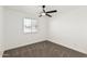 Bright bedroom features neutral carpet, a ceiling fan, and a window for natural light at 623 W Guadalupe Rd # 228, Mesa, AZ 85210