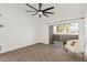 Well lit bedroom with a ceiling fan, carpet, white walls and a sliding door to the patio at 623 W Guadalupe Rd # 228, Mesa, AZ 85210