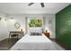 Bright bedroom with wood accent wall, modern furnishings, and views to the exterior at 6845 E Osborn Rd # D, Scottsdale, AZ 85251