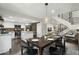 Open-concept dining area with modern staircase, table set for guests, and view into kitchen at 6845 E Osborn Rd # D, Scottsdale, AZ 85251