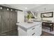 Modern kitchen island with white cabinets, gray countertop, and sliding barn door at 6845 E Osborn Rd # D, Scottsdale, AZ 85251