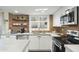 Well-lit kitchen with white cabinets, concrete countertops, stainless steel appliances, and open shelving at 6845 E Osborn Rd # D, Scottsdale, AZ 85251