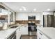 Modern kitchen featuring white cabinets, concrete countertops, stainless steel appliances, and a window at 6845 E Osborn Rd # D, Scottsdale, AZ 85251
