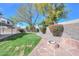 Backyard featuring a well-manicured lawn, mature trees, a fire pit, and privacy landscaping at 7420 W Los Gatos Dr, Glendale, AZ 85310