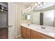 Double sinks with a large mirror in an oak-cabinet bathroom with tile floors at 7420 W Los Gatos Dr, Glendale, AZ 85310