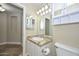 Bathroom featuring a vanity with a granite counter, a mirror and white cabinets for storage at 7420 W Los Gatos Dr, Glendale, AZ 85310