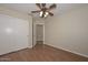 Comfortable bedroom with wood-look flooring, a ceiling fan with lighting, and a large closet at 7420 W Los Gatos Dr, Glendale, AZ 85310