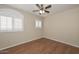 A sunlit bedroom with wood-look flooring, a ceiling fan, and shuttered windows at 7420 W Los Gatos Dr, Glendale, AZ 85310
